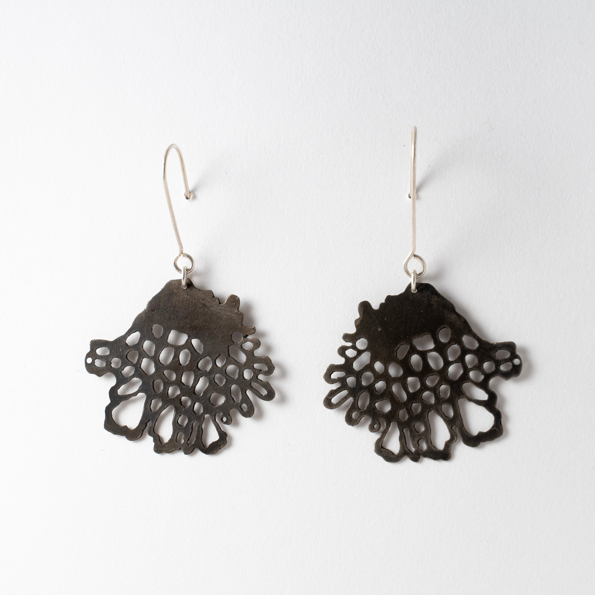 Pair of black lace-style earrings on a white background