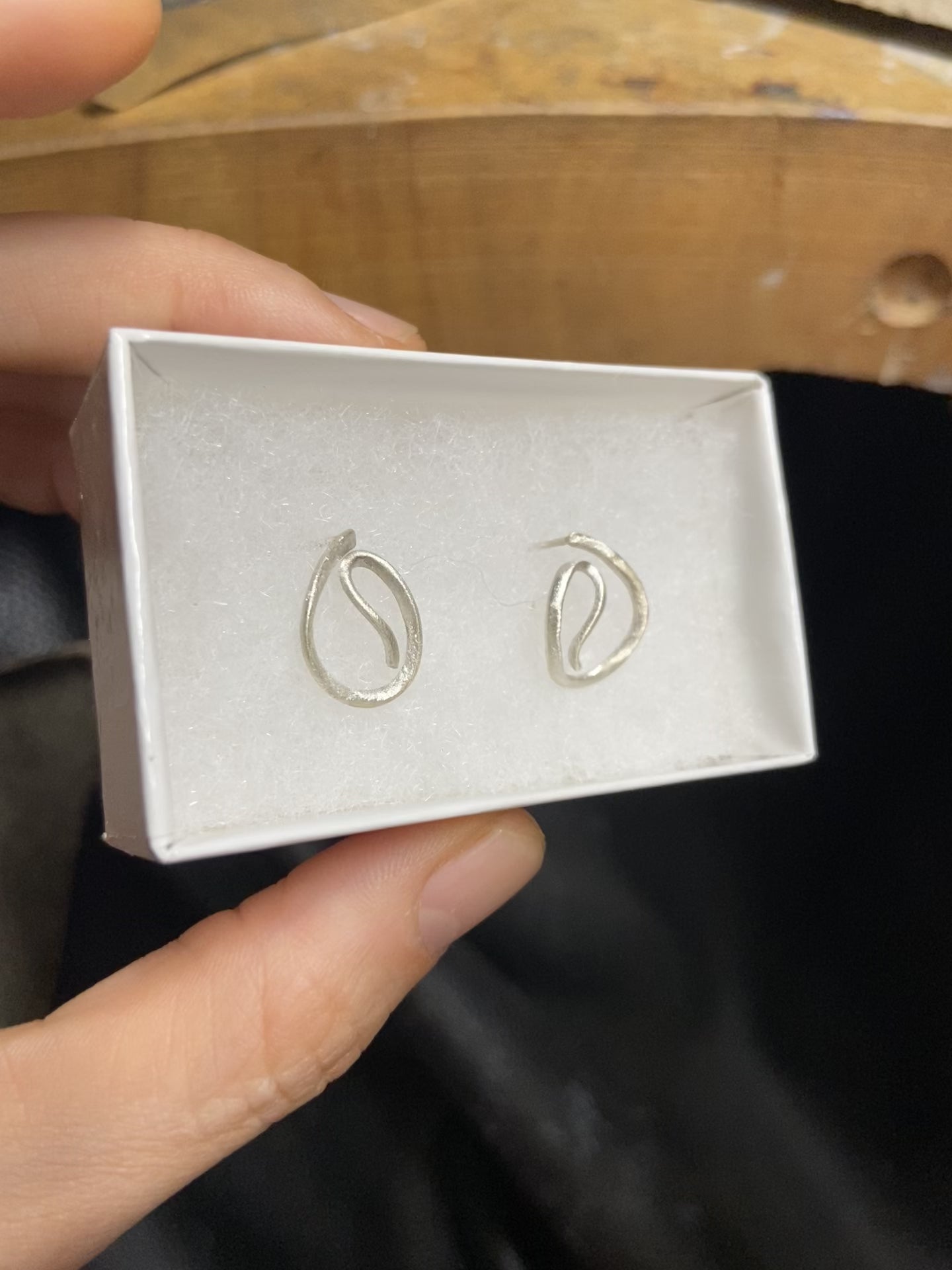 Close-up of unique scribble design stud earrings in sterling silver