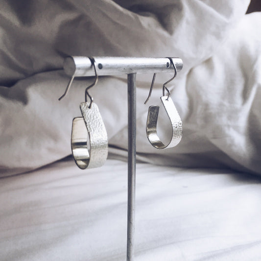 Bohemian with a hammered textured finish, silver, handcrafted open, teardrop, hoop earrings.