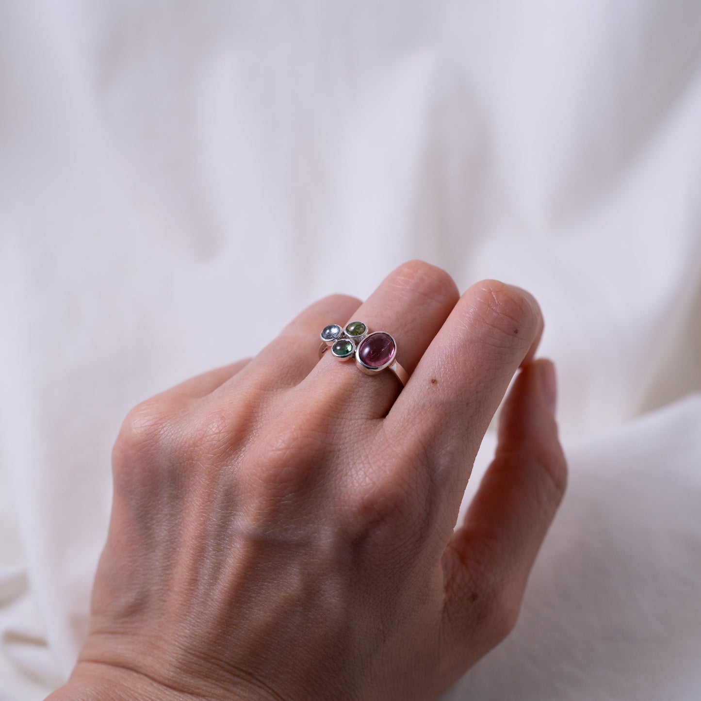 Hand fabricated pink and green tourmaline ring with a tanzanite cabochon set in silver