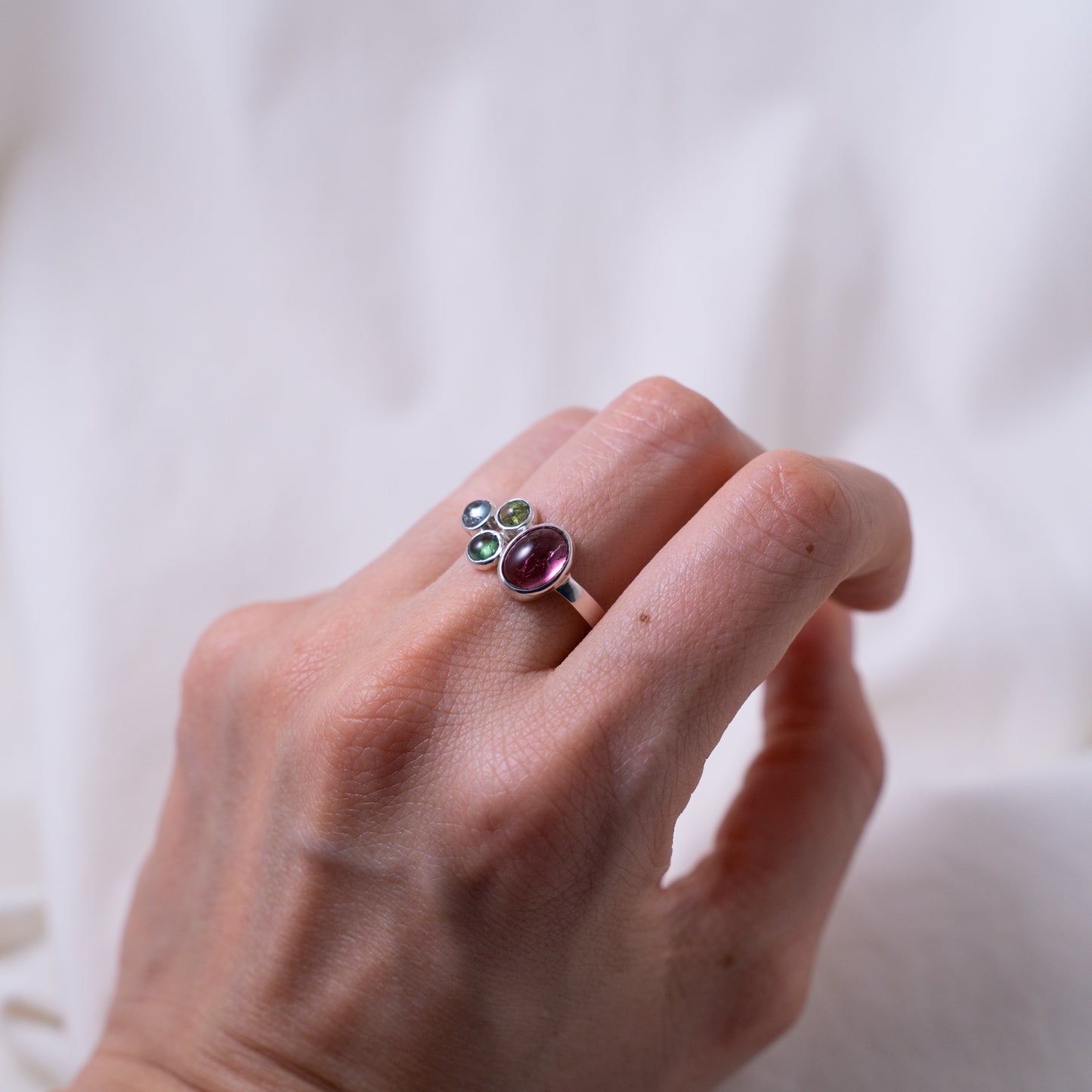 Hand fabricated pink and green tourmaline ring with a tanzanite cabochon set in silver