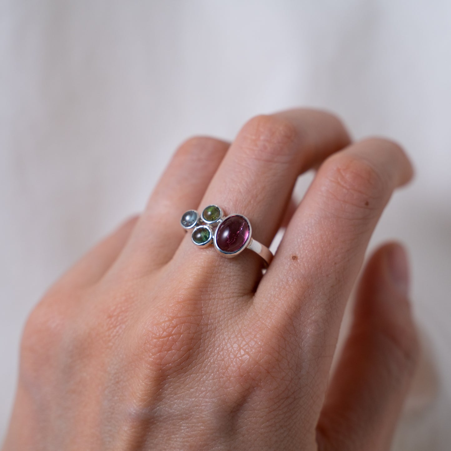 Hand fabricated pink and green tourmaline ring with a tanzanite cabochon set in silver