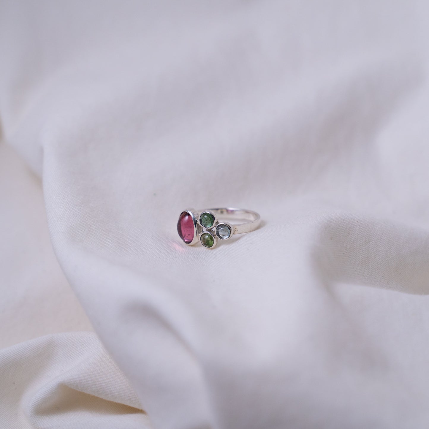 Hand fabricated pink and green tourmaline ring with a tanzanite cabochon set in silver