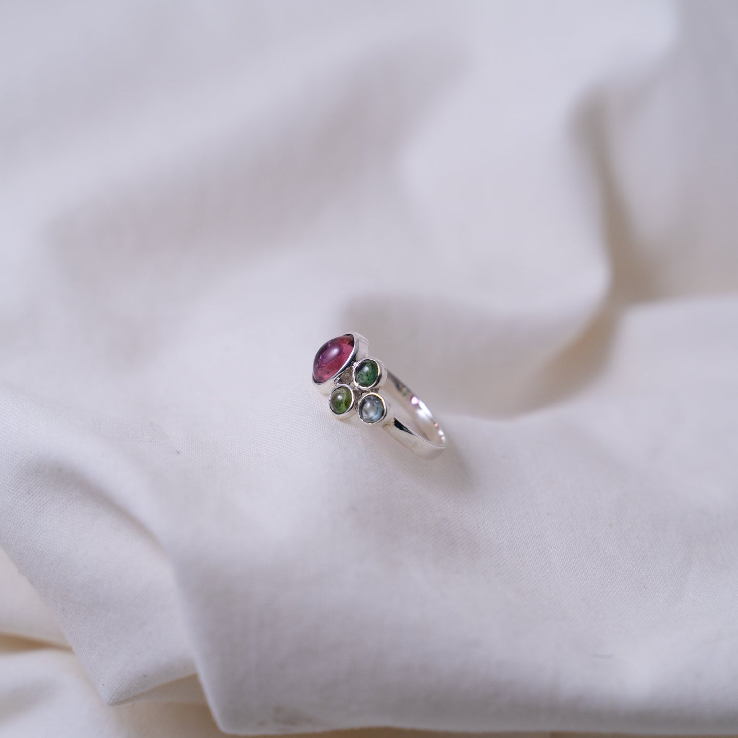 Hand fabricated pink and green tourmaline ring with a tanzanite cabochon set in silver