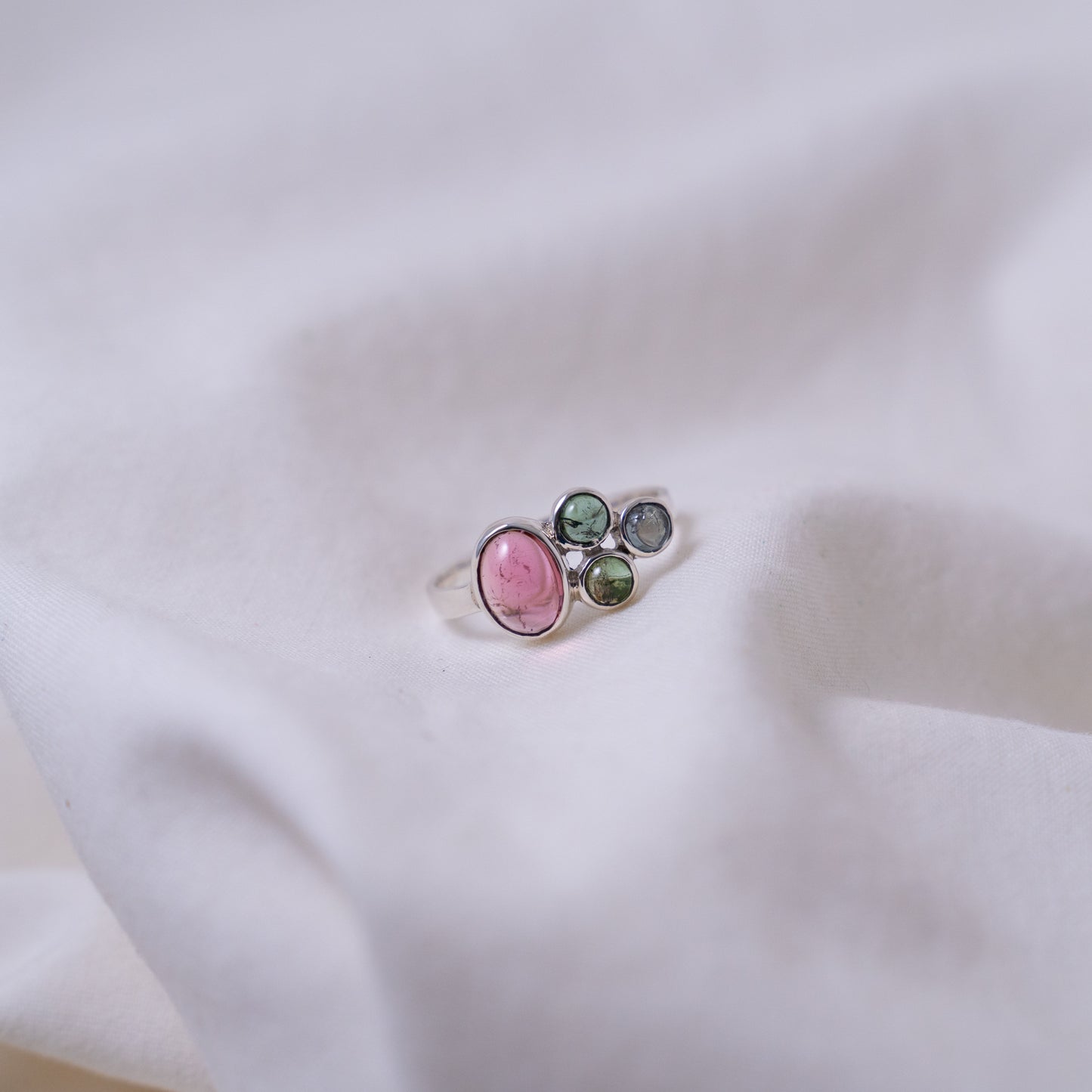 Hand fabricated pink and green tourmaline ring with a tanzanite cabochon set in silver