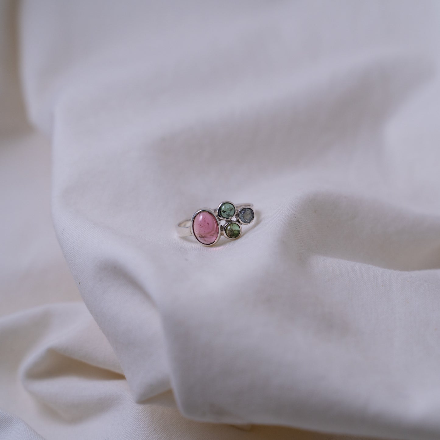 Hand fabricated pink and green tourmaline ring with a tanzanite cabochon set in silver