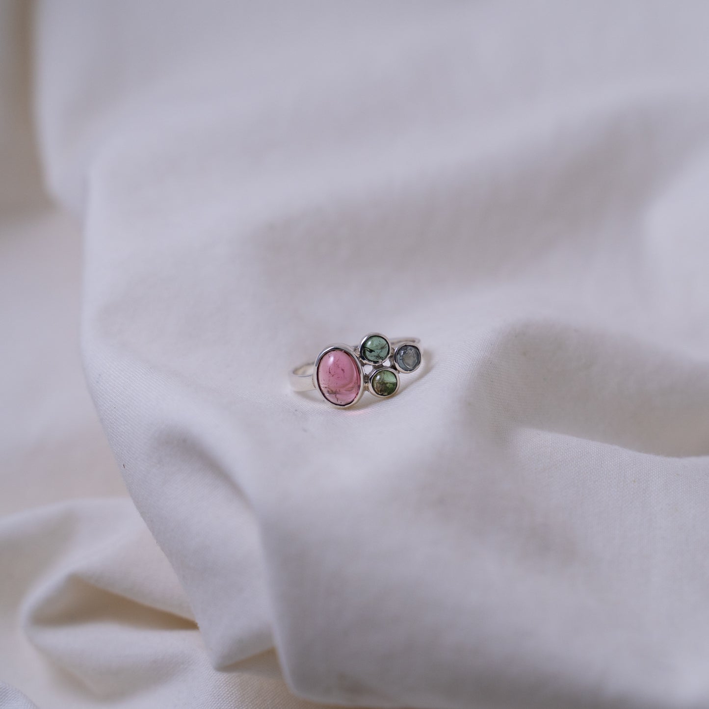 Hand fabricated pink and green tourmaline ring with a tanzanite cabochon set in silver