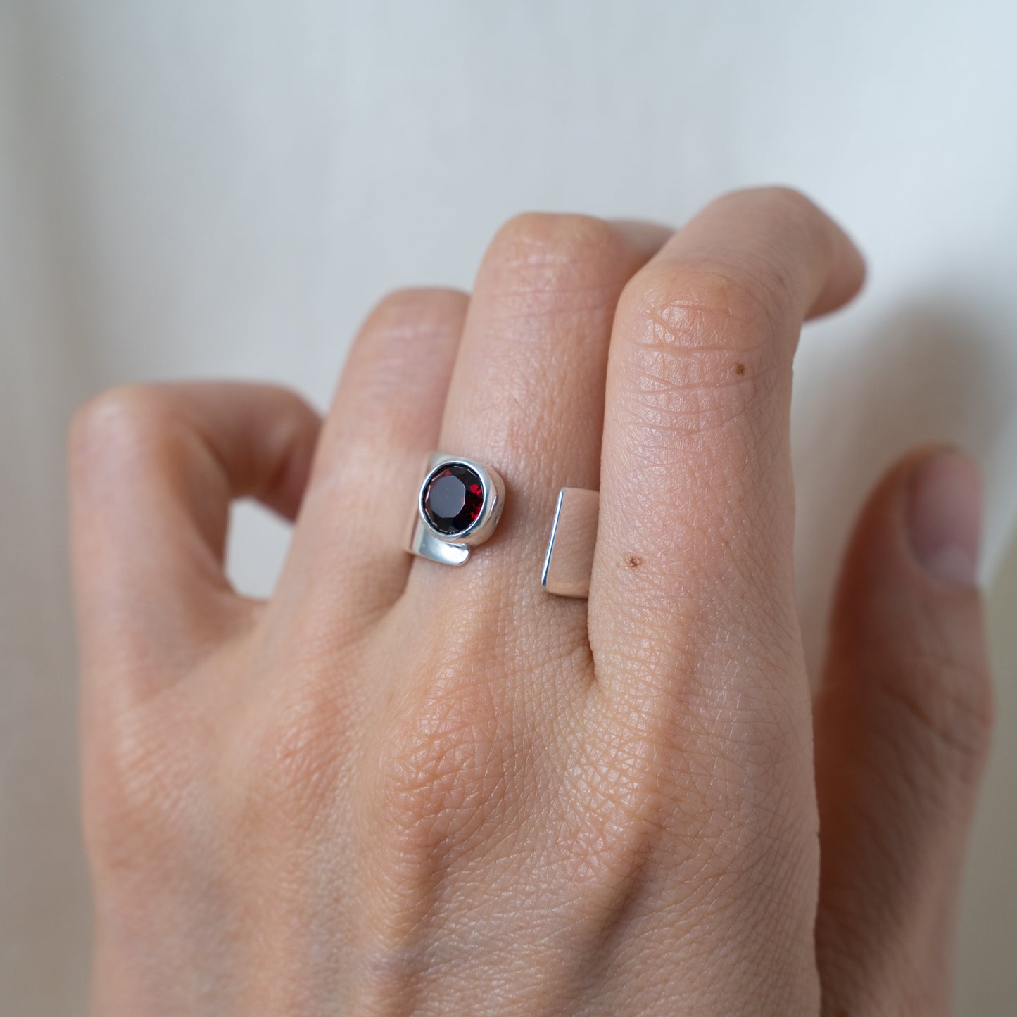 Round cut garnet, open sterling silver ring