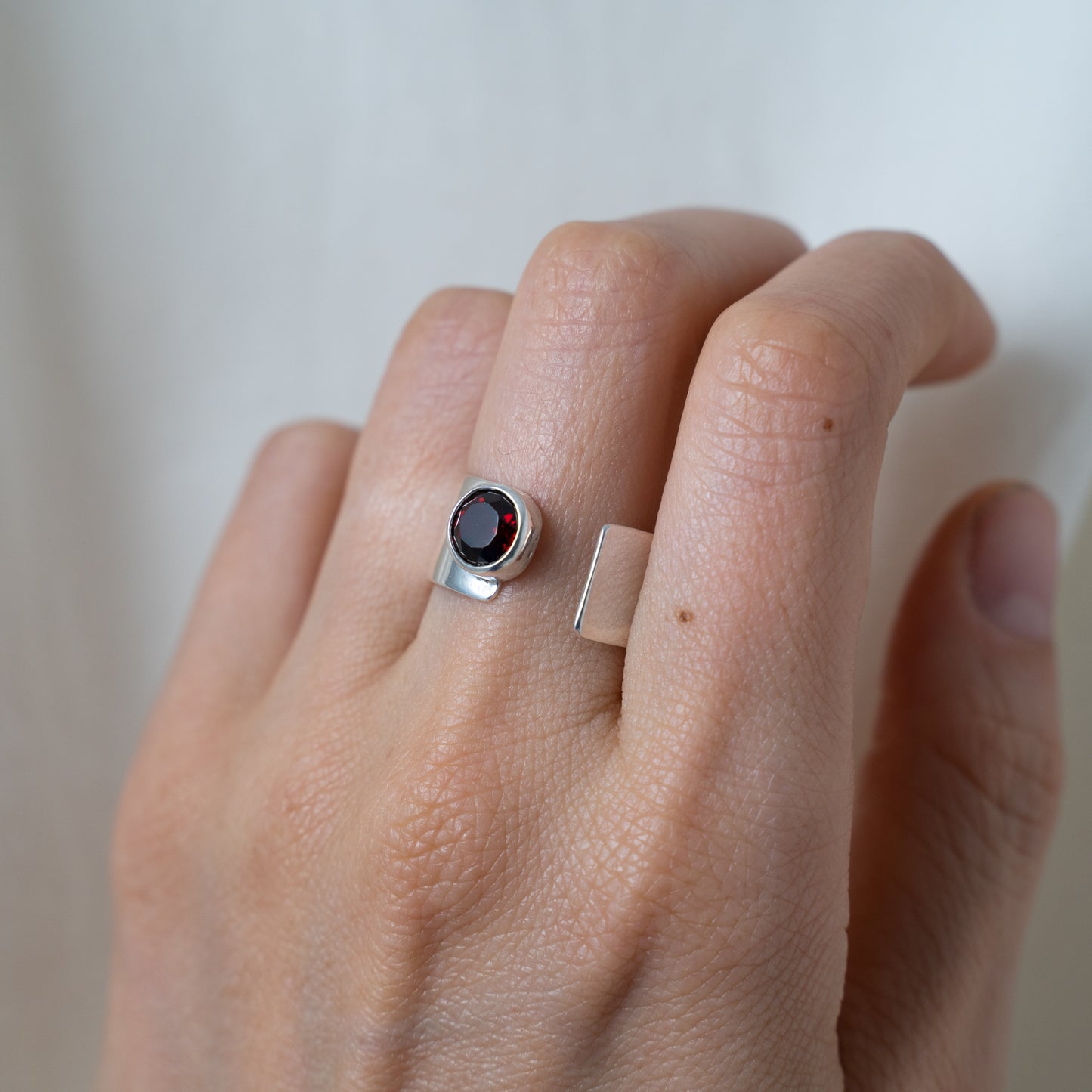 Round cut garnet, open sterling silver ring