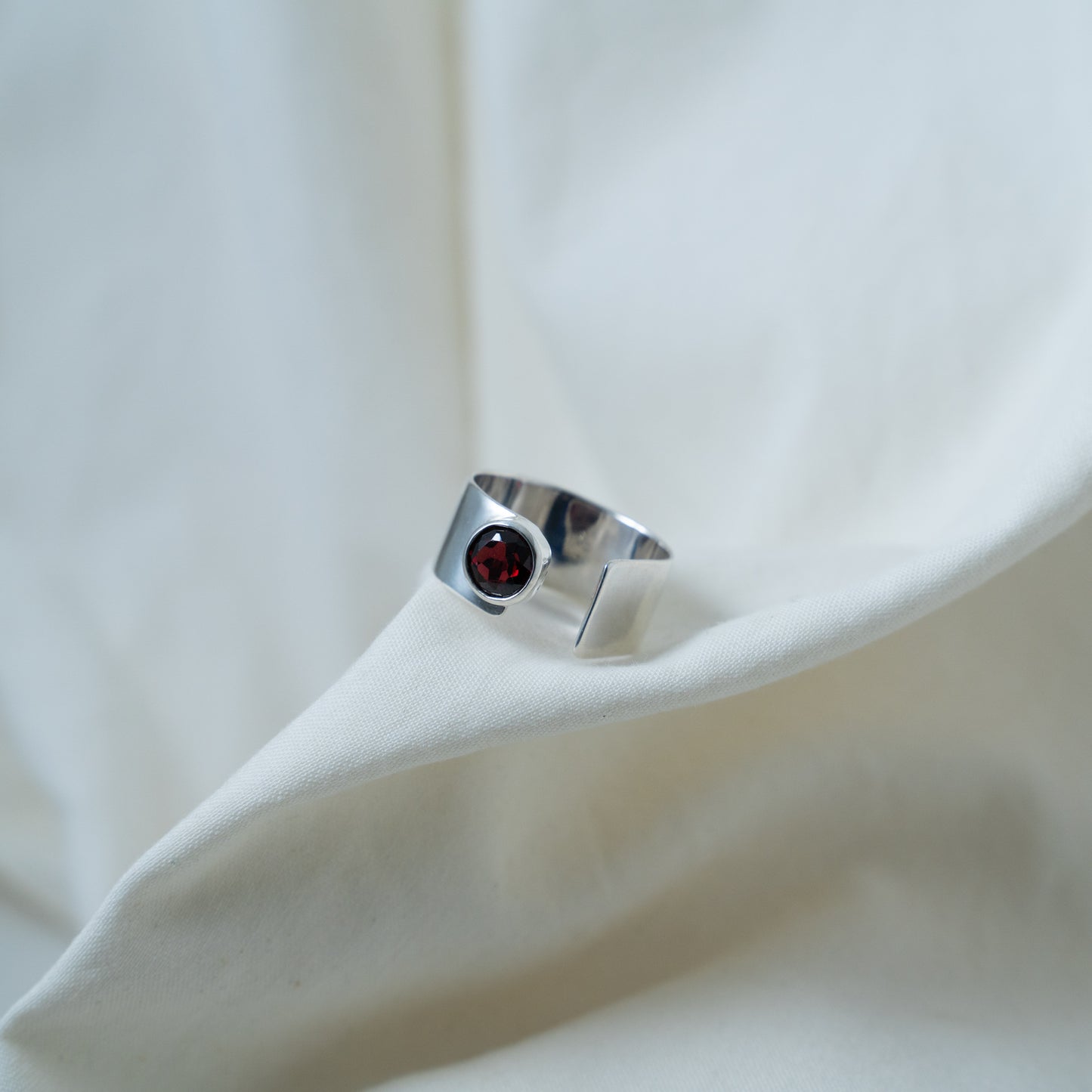 Round cut garnet, open sterling silver ring