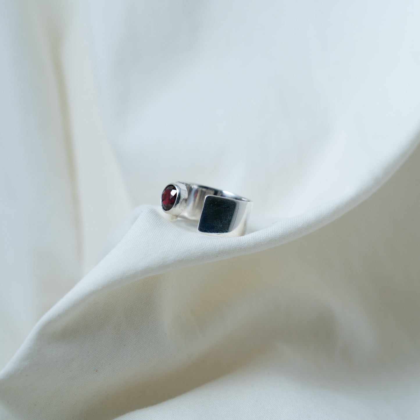 Round cut garnet, open sterling silver ring