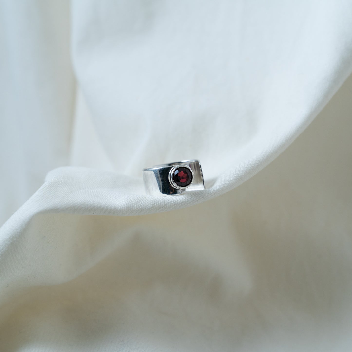 Round cut garnet, open sterling silver ring