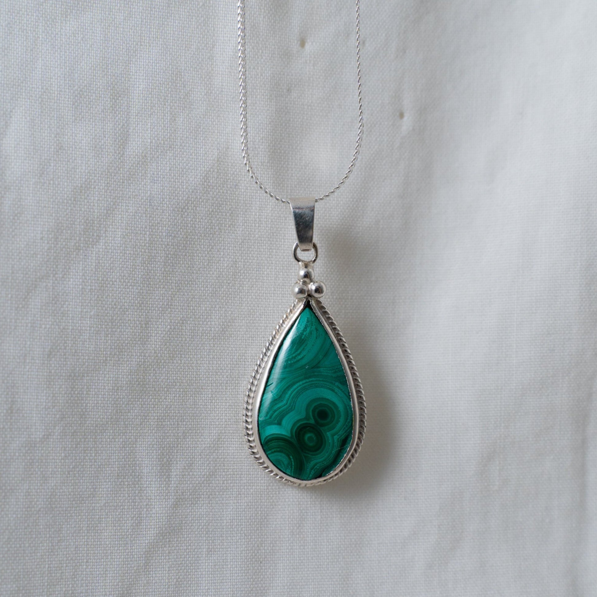 A head on shot of the teardrop malachite, silver pendant to depict how the pendant would look when worn.