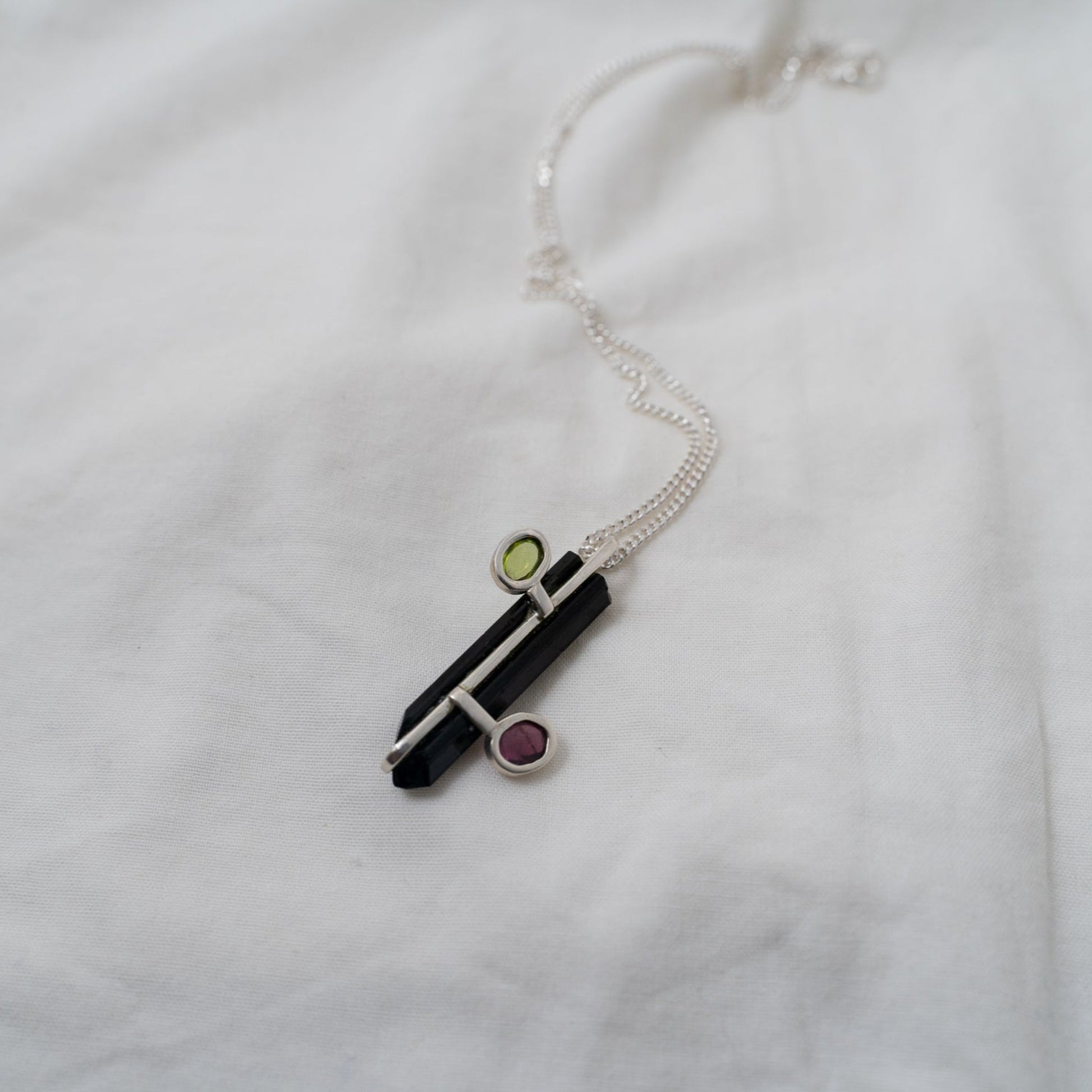 The back of the pendant gives a sense of how this piece is created and made. The black tourmaline being the anchor and the hold for the two oval gemstones on either side.