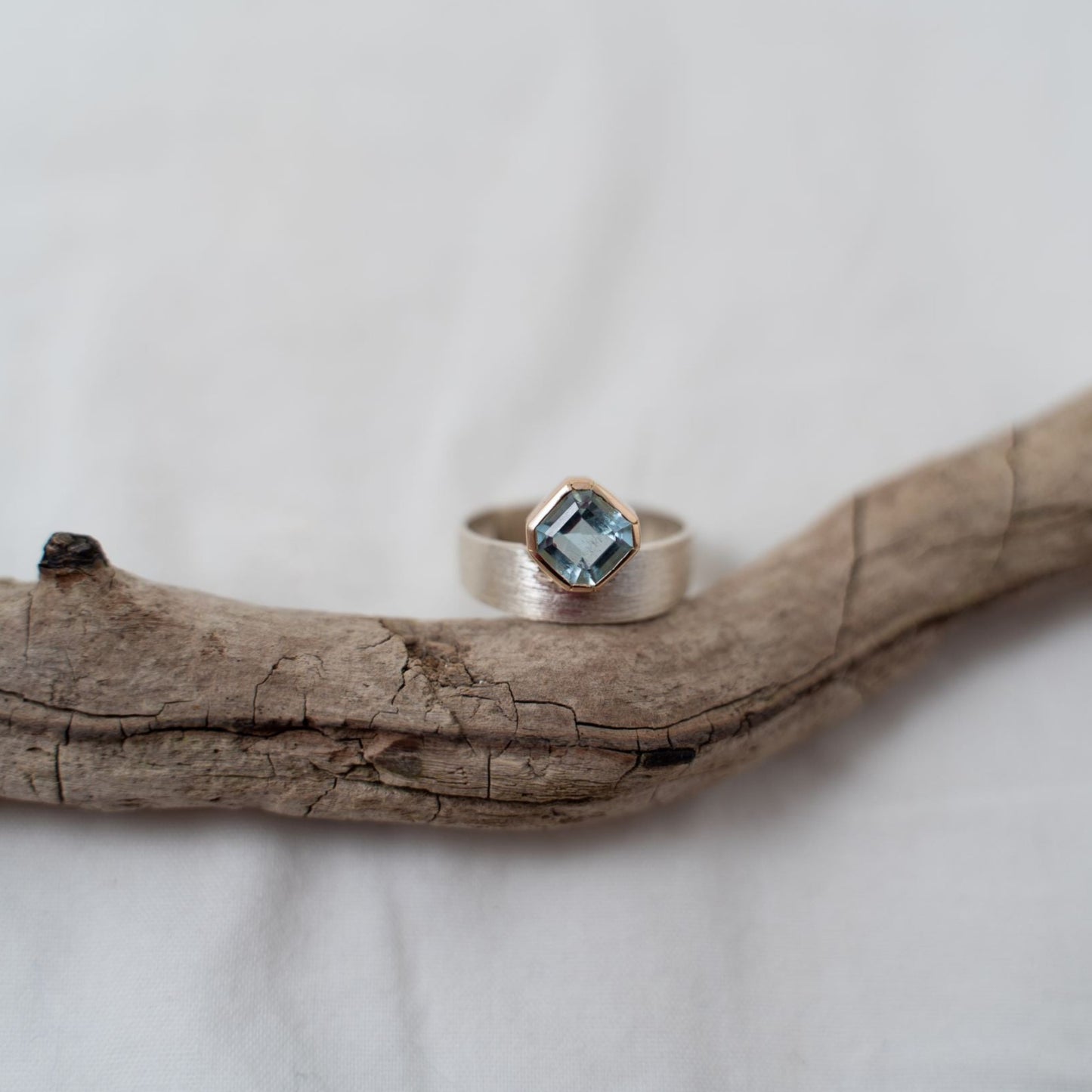 Asscher cut aquamarine set in gold on a silver ring