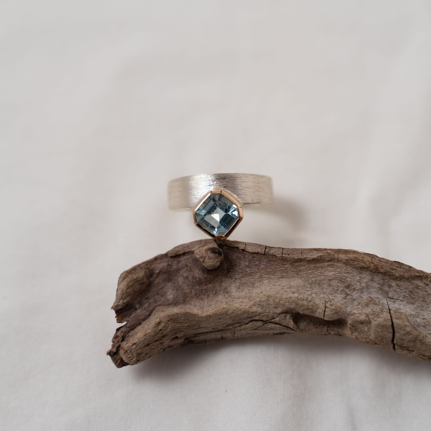 Asscher cut aquamarine set in gold on a silver ring