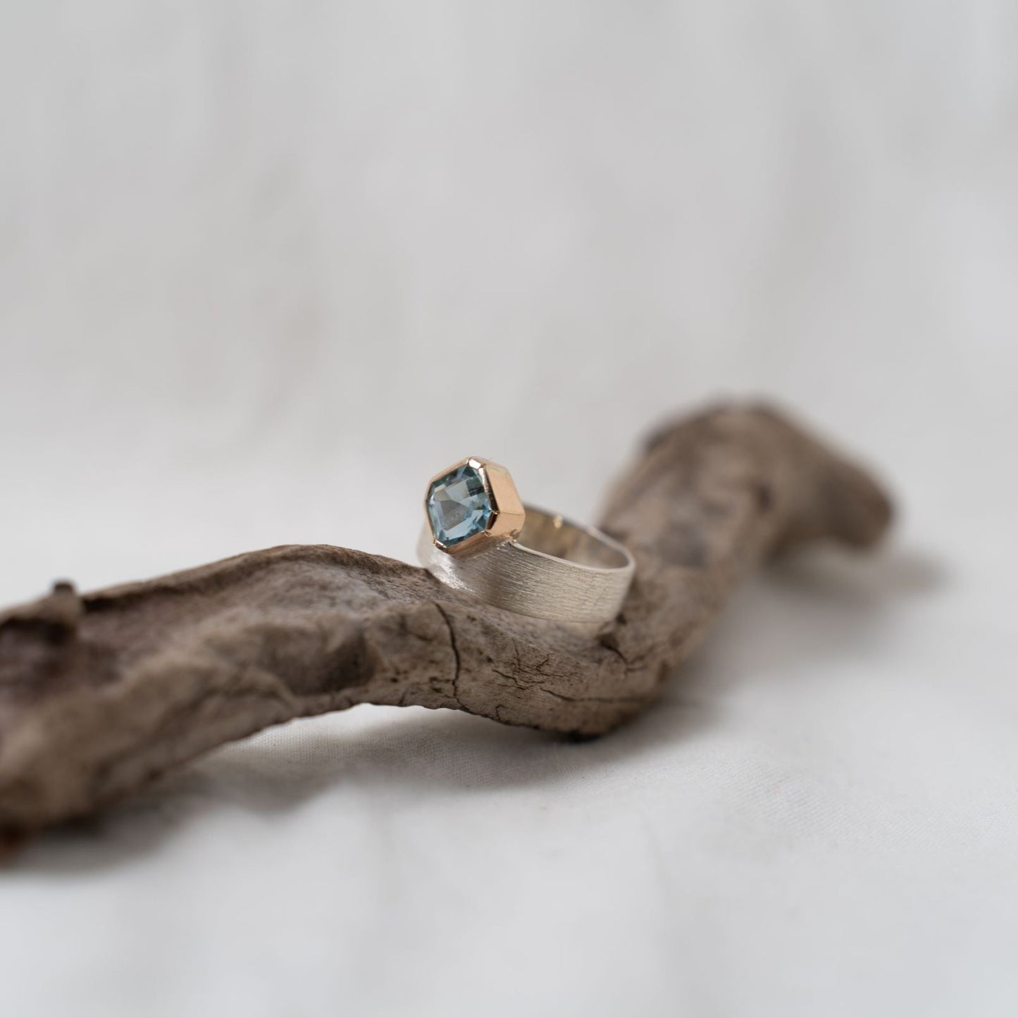 Asscher cut aquamarine set in gold on a silver ring