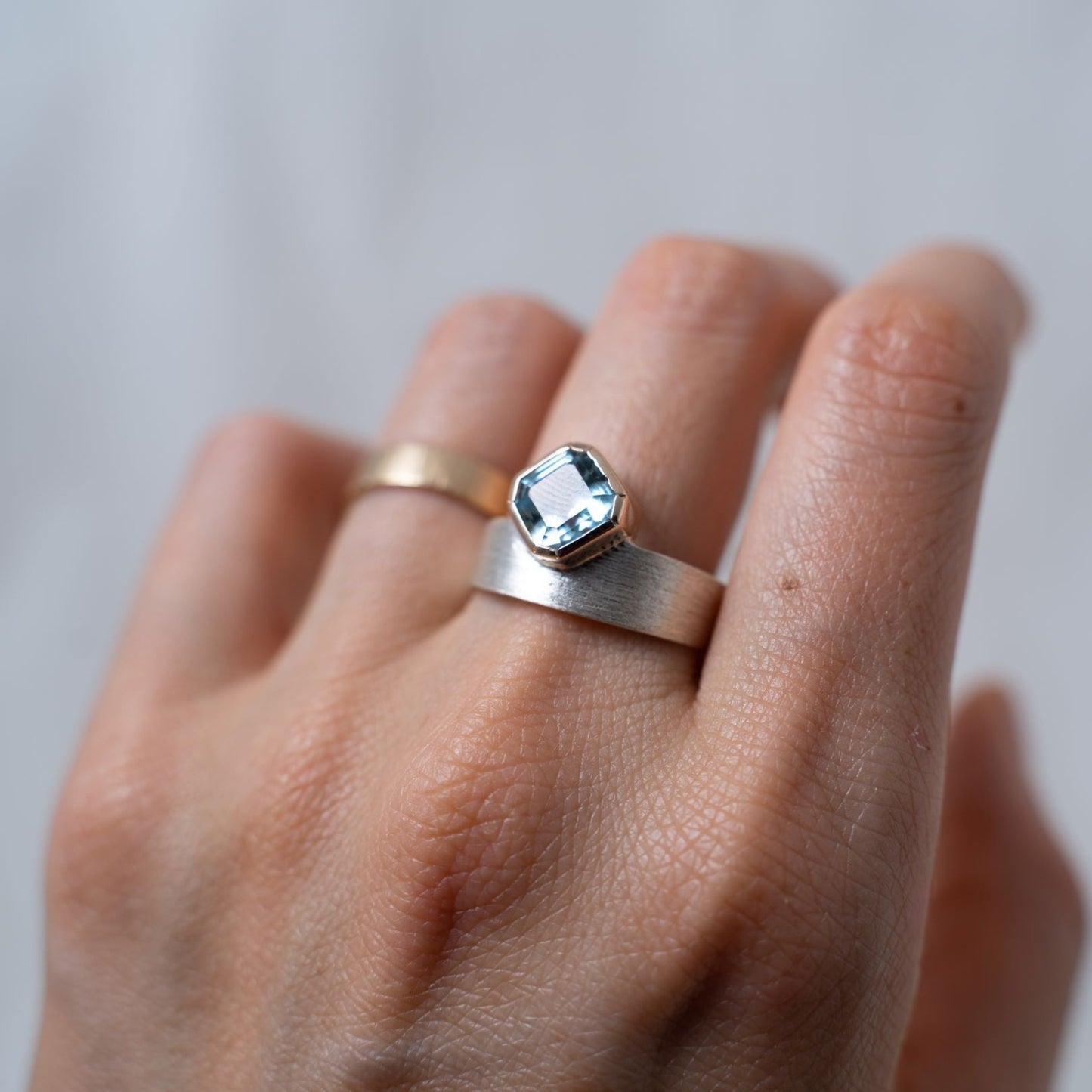 Asscher cut aquamarine set in gold on a silver ring