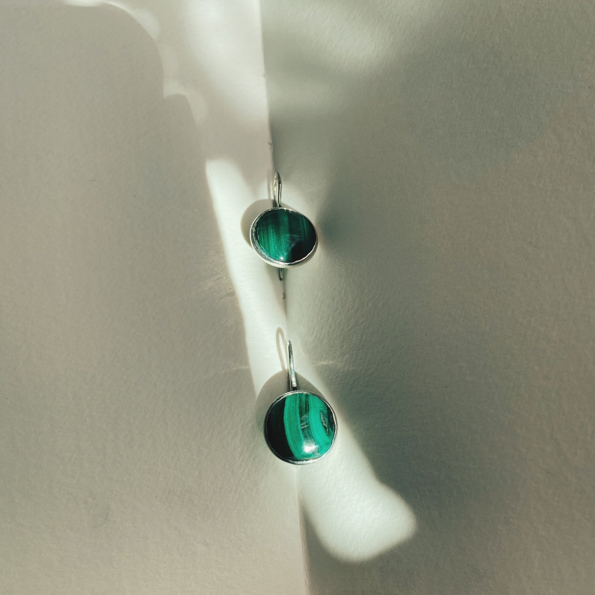 Lovely dangle, emerald green like malachite earrings with vertical dark green lines running down the length of the malachite.