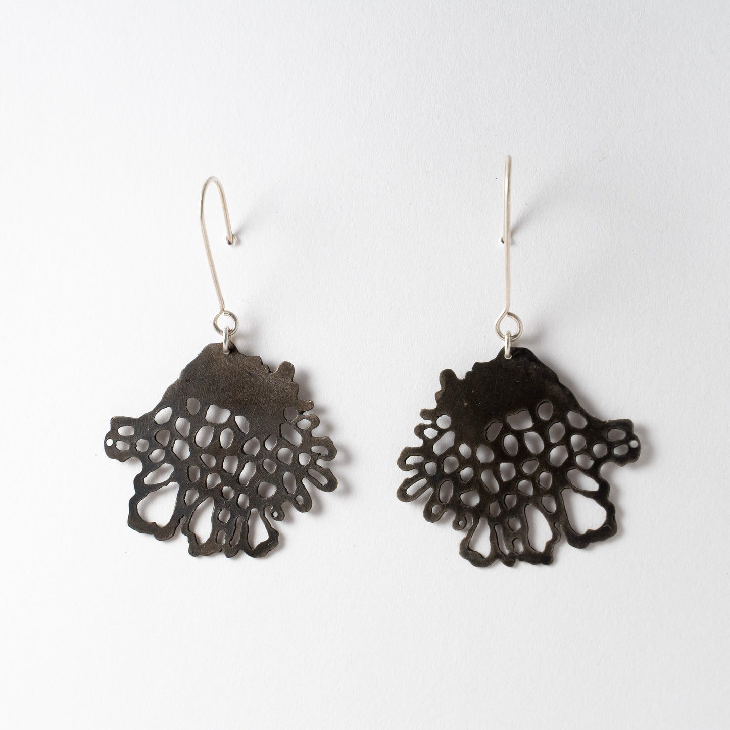 Pair of black lace-style earrings on a white background